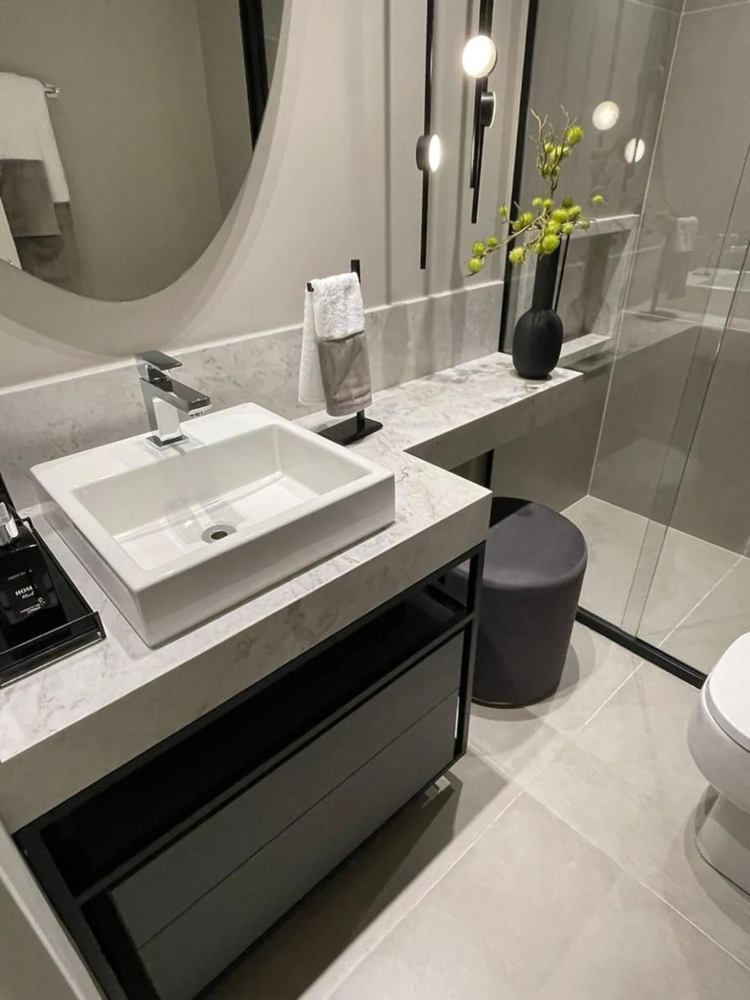Banheiro com bancada em mármore branco e cuba de apoio